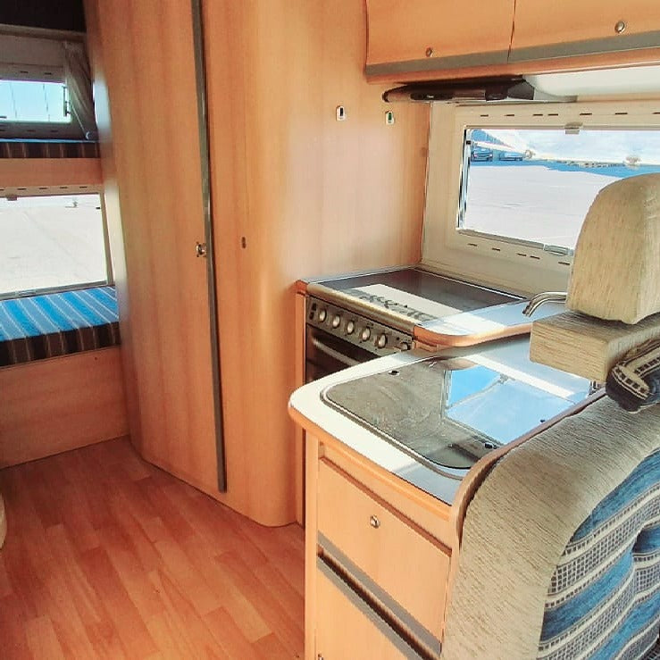 Interior de autocaravana Elnagh Super D 110 con salón comedor y literas, ideal para viajar en familia por Canarias