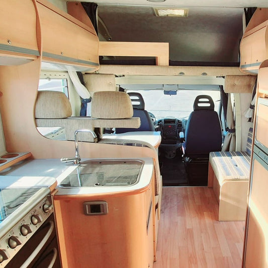 Comedor con asientos giratorios y cocina en autocaravana de segunda mano en Canarias – Elnagh Super D 110